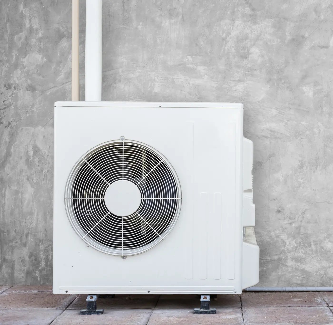 An outdoor air conditioning unit installed on a concrete wall