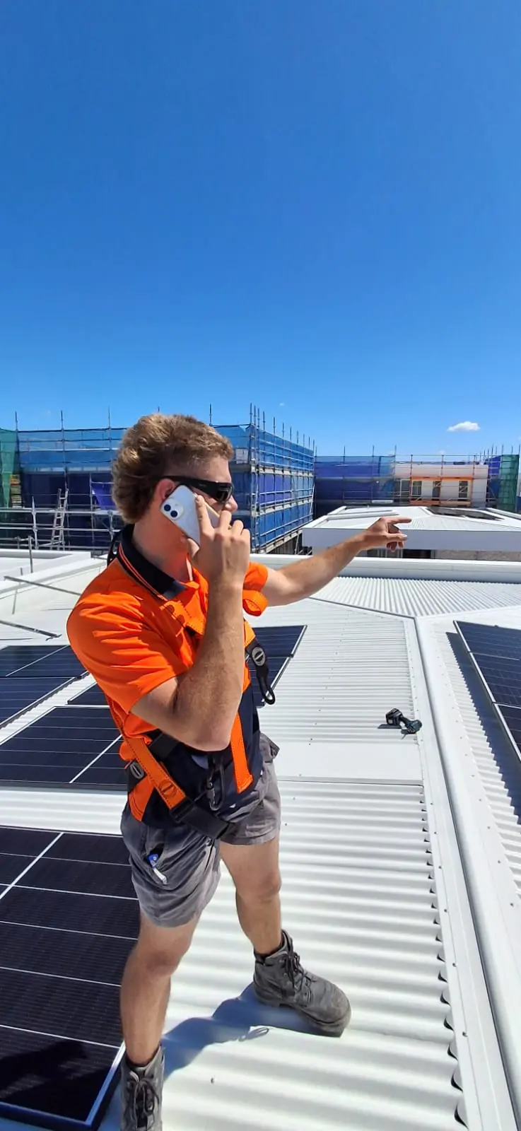 An installer on a roof among new solar panels